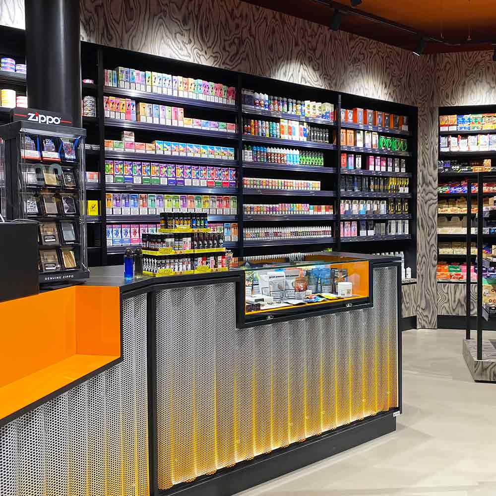 Kassenbereich der Smokee-Headshop-Abteilung mit Zigaretten und Vapes im Hintergrund.